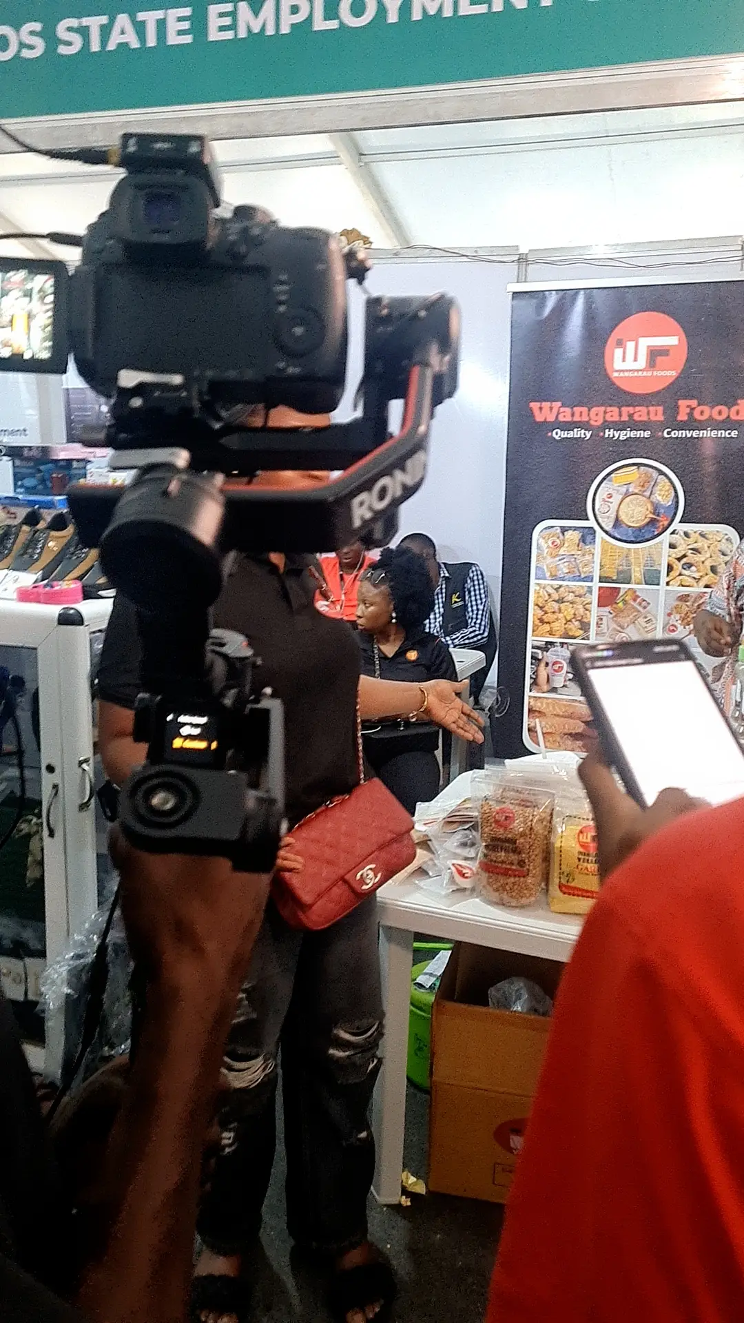 Wangaraufoods booth with Head of Sales being interviewed by LSETF at The International Trade Fair 2024, showcasing products on display.